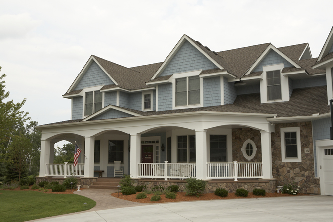 elegant-traditional-home-exterior-blue-shaker-siding-patriotic-columns-stone-transom