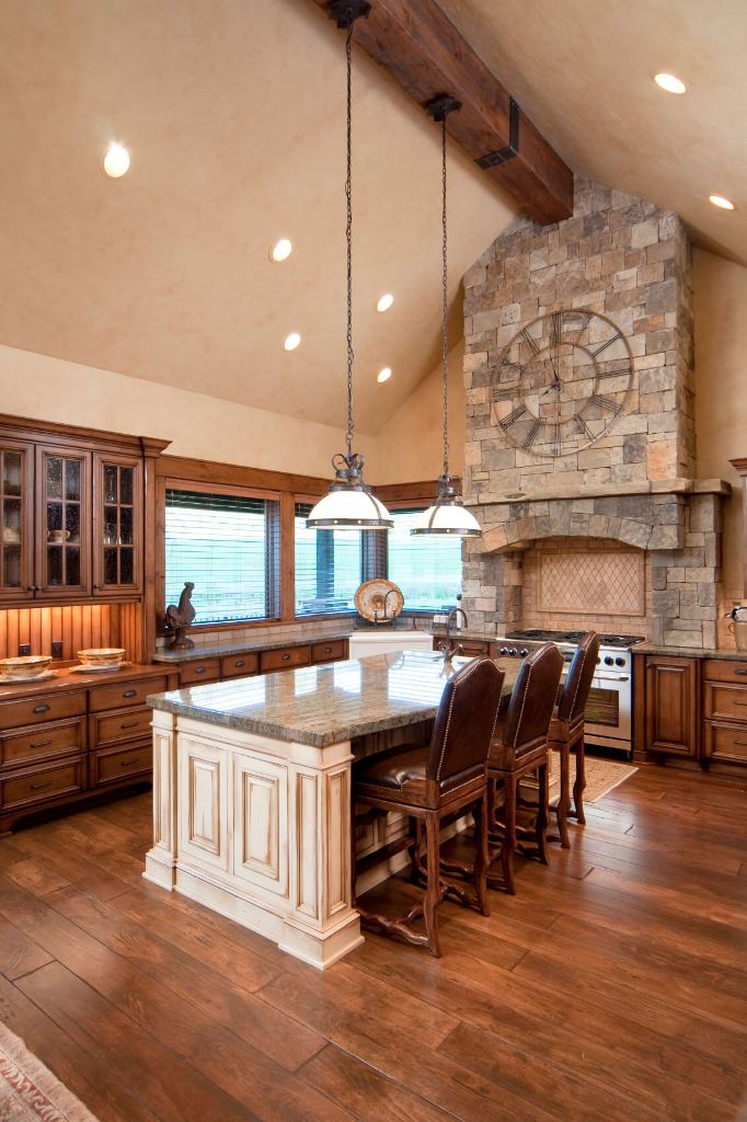 This kitchen is flush with warm natural wood tones, natural stone wall above the range