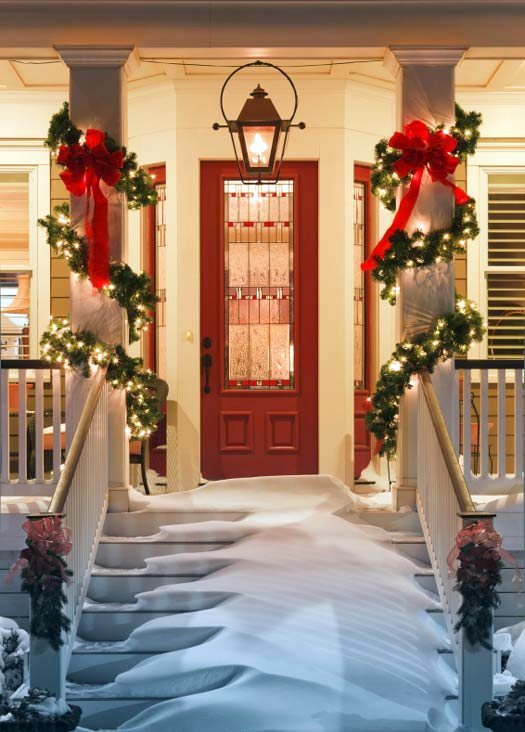 inviting doorway with snow on porch stairs and railing