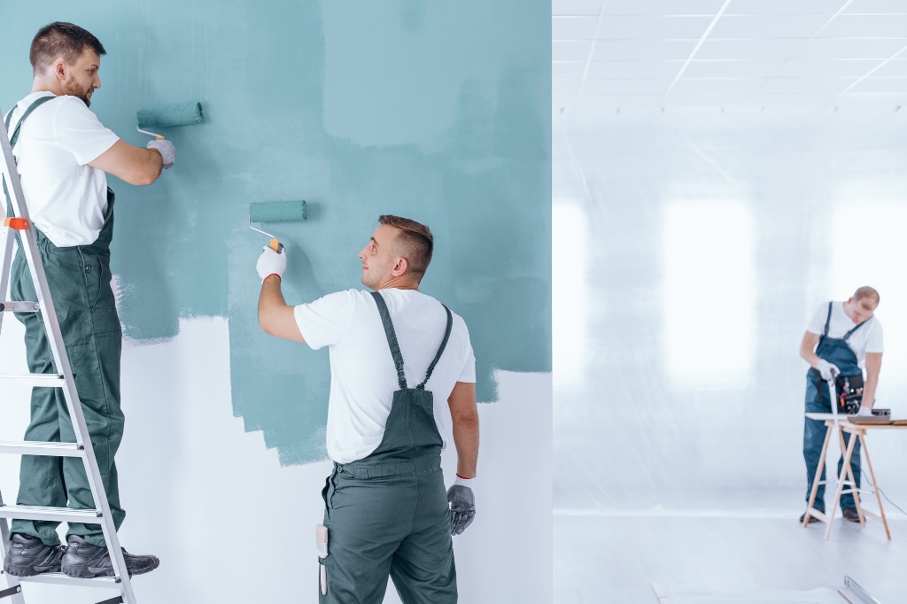 Men painting the wall blue using rollers in empty home interior